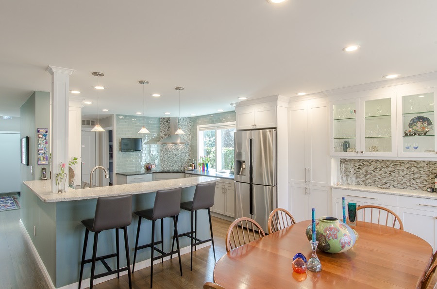 Seating for 3 at the peninsula, a corner stove and a soft color palette highlight this transitional kitchen.