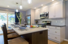 The Two Toned Kitchen makes a bold statement by contrasting white cabinets with a dark brown island.