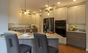 Two hanging lights accent the grey peninsula which seats two.