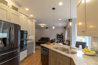 Glass cabinets top the white cabinets, elegantly displaying decor.