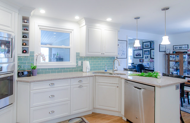This medium white kitchen features wine racks, extra prep space and brand new countertops.