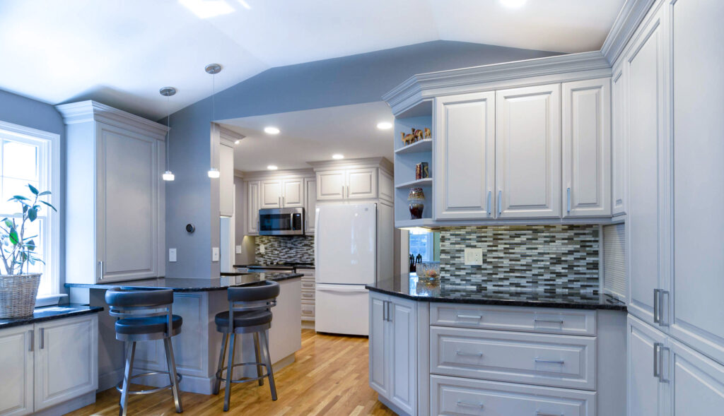 This uniquely shaped kitchen features dreamy white cabinets and black countertops.