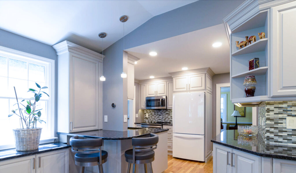 This uniquely shaped kitchen has a custom countertop that wraps around this T-shaped wall.